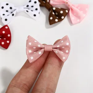 Detailed close-up view of a small pink polka dot grosgrain ribbon bow accessory for DIY