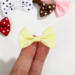 Close-up detail of a mini yellow polka dot grosgrain bow for DIY hair accessory projects