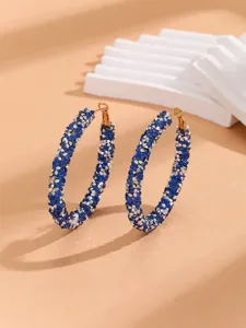 Close-up of dazzling blue and silver rhinestone large hoop earrings, elegant jewelry detail shot.