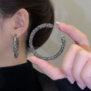 Detailed view of glittering rhinestone hoop earrings, showing elegant fashion jewelry details.