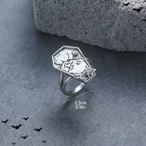 Gothic punk coffin ring detail showing intricate skull and rose carvings on textured background.