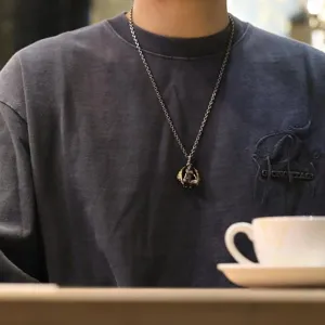 Detailed shot of trendy gothic devil angel necklace pendant for men and women, stylish.