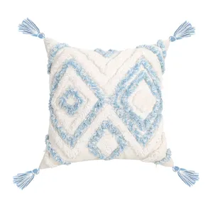 Nordic style tufted throw pillow with blue geometric pattern and four corner tassels.