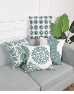 Decorative throw pillow covers set featuring stylish embroidered geometric patterns on sofa.