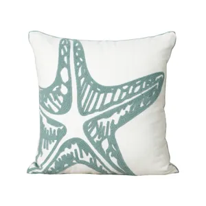 White cotton throw pillow featuring a teal starfish embroidery design for modern home decor.