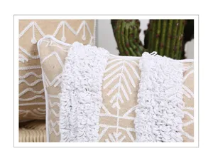 Nahaufnahme des nordischen Vintage-Tufted-Zierkissens mit geometrischer weißer Stickerei.
