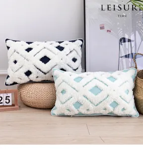 Detailed view of geometric tufted cushion cover with plush fringe and soft fabric texture.