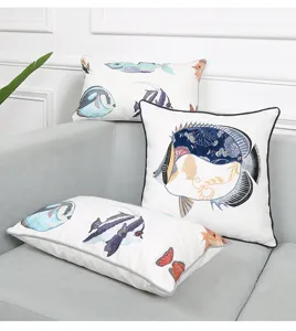Vista detallada de cojines decorativos bordados con peces marinos en sofá gris, elegante.