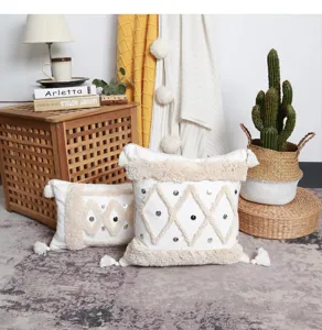 Detail shot of nordic boho tufted throw pillow with geometric patterns and tassels in cozy setting.