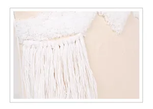 White cotton tufted pillow cover detail, boho moroccan fringe and tassel texture close up