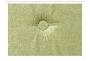 Close-up detail of green tufted cushion fabric texture with central button tufting design.