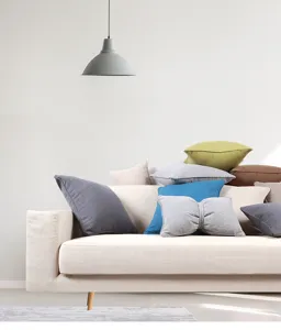 Detailed view of assorted colored fabric throw pillow covers in a modern living room setting.