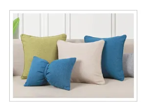 Linen throw pillow detail showing neat arrangement of solid color and bow cushion in room.