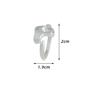 Bague en alliage argenté mat avec un design de masque de visage abstrait et dimensions.