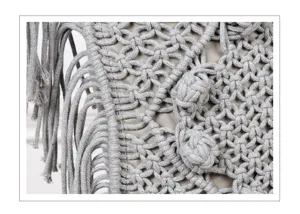 Detailed view of handmade gray macrame woven throw pillow cover texture with fringe