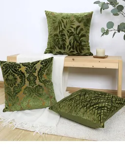 Green velvet throw pillow cover detail, plant and geometric jacquard pattern cushion.
