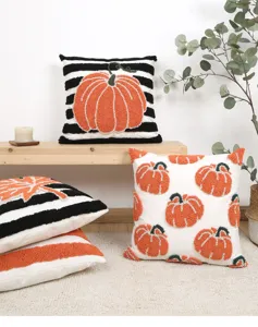 Detailed view of tufted pumpkin embroidered cushion covers with striped and autumn theme designs.