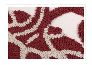 Primer plano de los detalles de la funda de cojín tufting con patrones de hilo rojo.