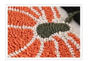 Detail of orange pumpkin tufted pillow cover, geometric stripe cushion for sofa and bed.