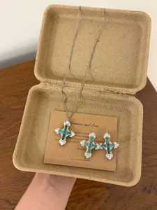 Set collana orecchini croce zircone smeraldo, vista dettagliata, eleganti gioielli di nicchia.