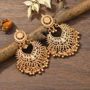 Bohemian gold-toned hollow drop earrings with intricate filigree crescent design and hanging beads.