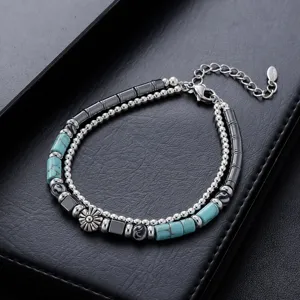 Bracelet de perles double couche avec turquoises, tubes en métal et charm floral tendance.