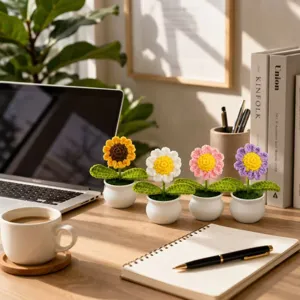 Handgefertigte Häkel-Topfblumen mit bunten Gänseblümchen und Sonnenblumen für die Schreibtischdeko.