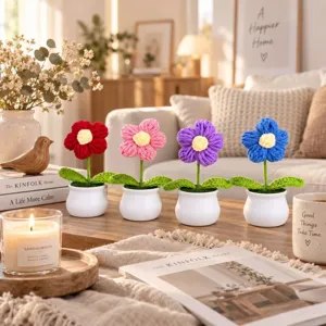 Close-up detail of handmade crochet puff flower potted plants, charming desktop decoration.