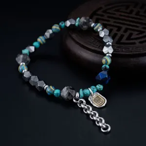 Bracelet de perles en pierres précieuses avec hématite irrégulière et pendentif en métal.