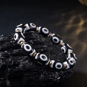 Close-up view of the Tibetan style nine-eye dzi bead bracelet featuring metal spacers.