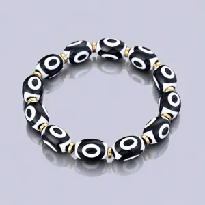 Tibetan style black and white eye dzi bead bracelet with gold metal spacers for daily wear.
