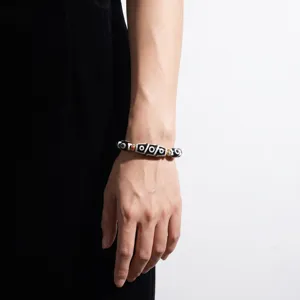 Close-up detail of Tibetan Dzi bead bracelet featuring black and white eye patterns.