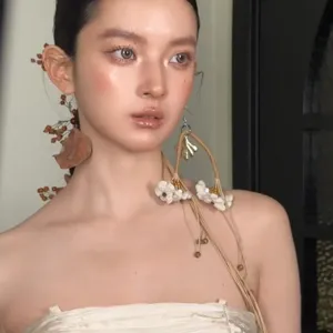 Close-up of artistic retro dried flower long tassel earrings on model, unique niche design.