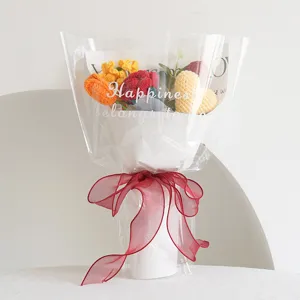 Bouquet di fiori all'uncinetto fatto a mano con girasoli e rose in confezione regalo.