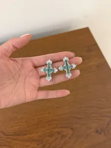 Orecchini a croce in zircone verde dettaglio con elegante intarsio di pietre preziose lucide.