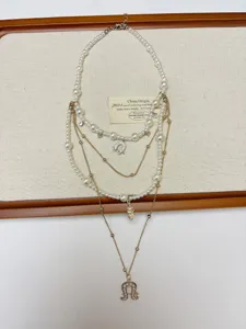 Detailed shot of multi-layer pearl and gold chain necklace with moon pendant, elegant jewelry.
