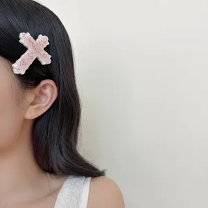 Close-up detail van een schattige roze kruis haarspeld met Japanse kaomoji en sterren.