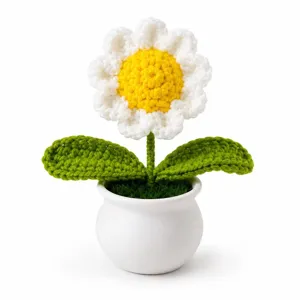 Nahaufnahme Detail der handgefertigten Häkel-Gänseblume im weißen Topf als schicke Deko.