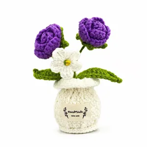 Planta en maceta de rosas violetas de ganchillo hecho a mano, detalle de decoración.