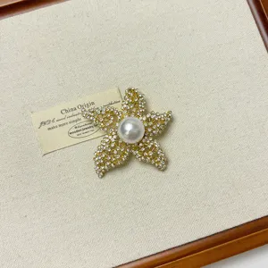 Exquisite rhinestone pearl five-pointed star brooch detail, elegant metal accessory pin.