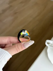 Close-up of a colorful toucan enamel open ring, unique metal jewelry detail shot.