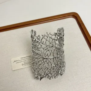 Detail view of the statement metallic open cuff bracelet, featuring unique branch texture for women.