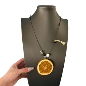 Orange slice necklace detail, long sweater chain with wooden beads and fruit pendant.