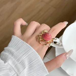 Close-up of a gold marine crab ring featuring red shell texture and sparkling crystal eye detail.