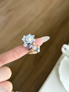Detailansicht des eleganten Perlen- und Muschelrings im Ozean-Stil mit feiner Textur.