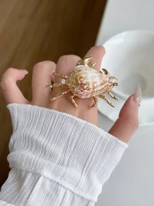 Bohemian style seashell conch ring with gold metal finish and delicate open design.