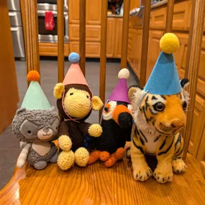 Vue détaillée des chapeaux de fête en feutre coloré avec pompons pour animaux de compagnie.