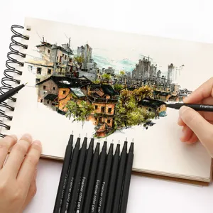 Vue détaillée de feutres fins colorés dessinant un paysage urbain dans un carnet à spirale