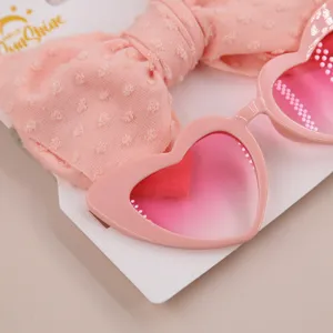 Detailaufnahme der rosa Herz-Sonnenbrille für Kinder mit passendem Schleifenstirnband