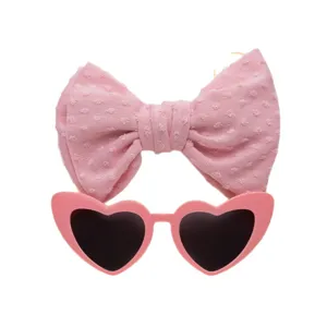 Set mit Retro-Herz-Sonnenbrille und passendem rosa Schleifenstirnband für stylische Mädchen